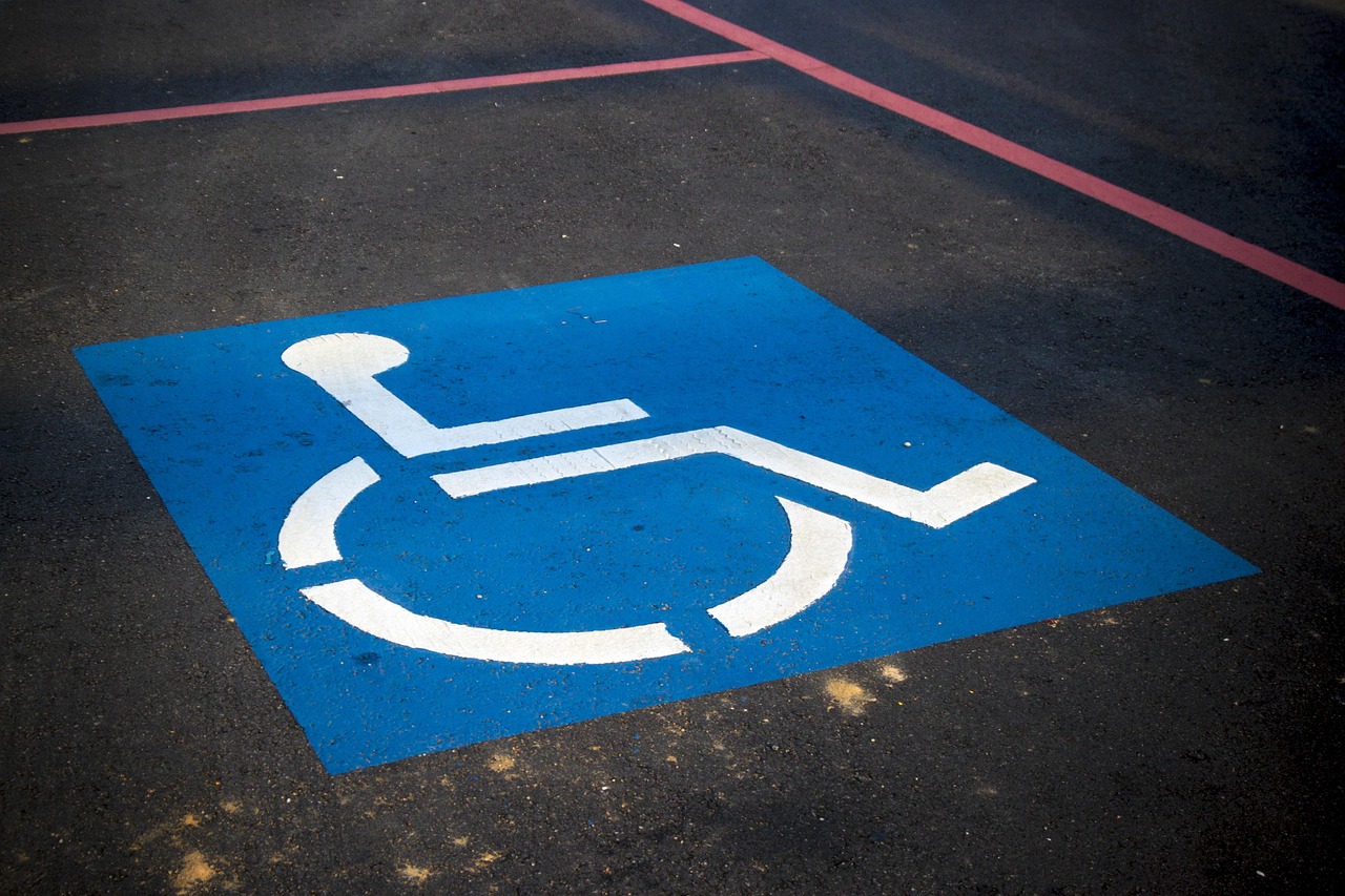 ADA handicap parking spaces with blue markings and International Symbol of Accessibility painted on asphalt